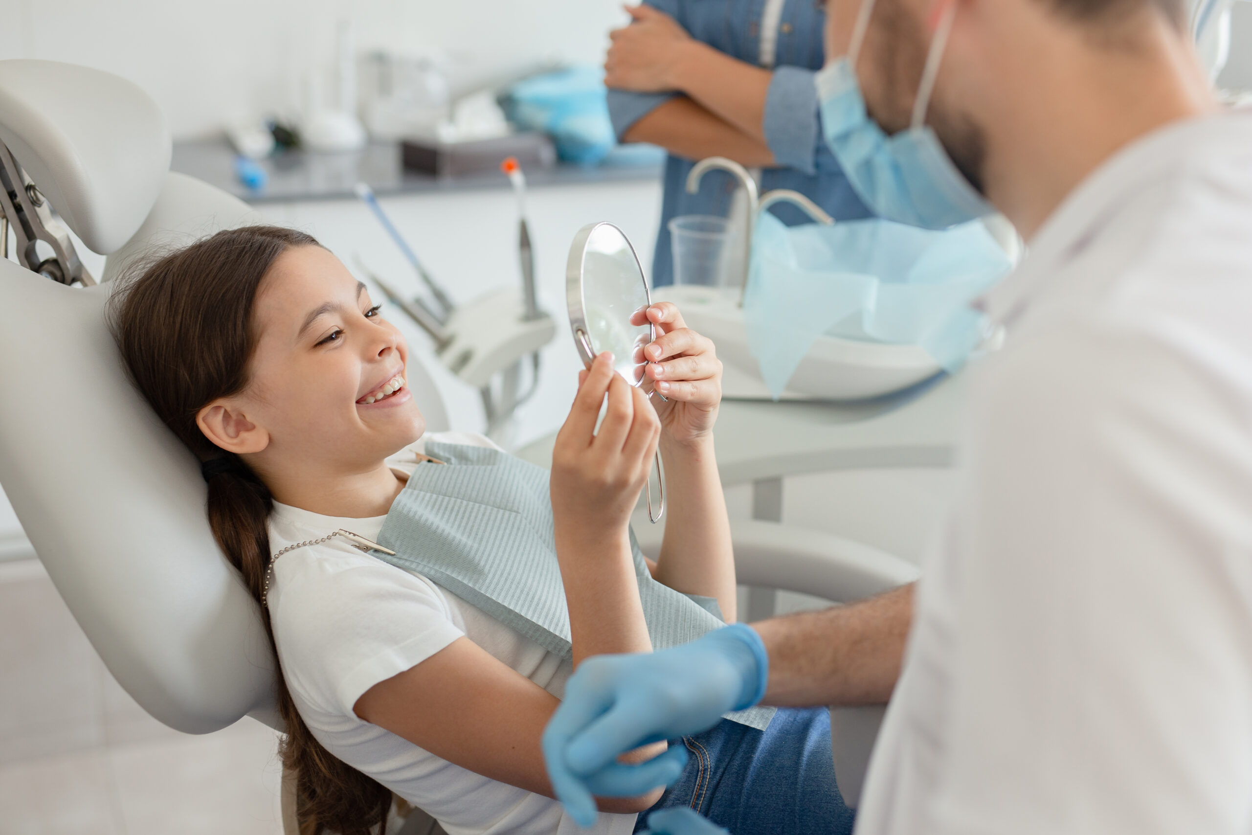 child in a dental chair smiling in a mirror