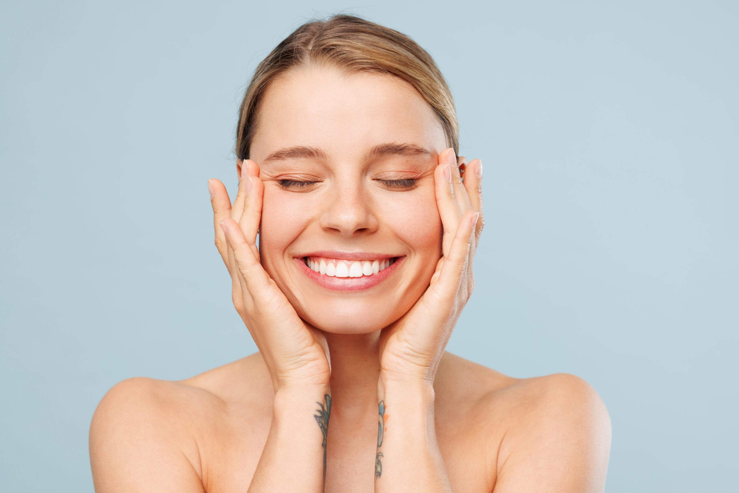 young woman smiling against a light blue background